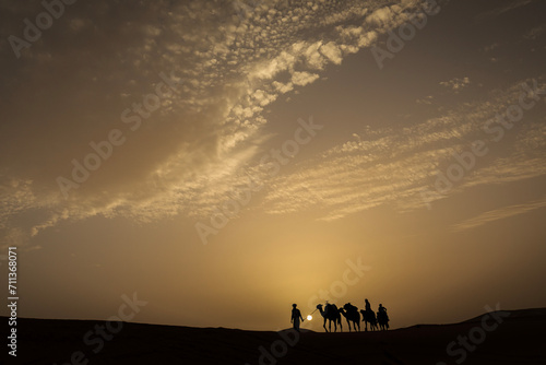 Silhouette of camel caravan with beautiful clouds in background in Sahara  Merzouga  Morocco