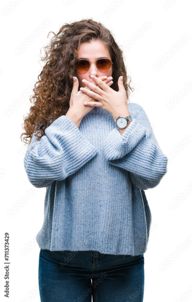 Beautiful brunette curly hair young girl wearing sunglasses over isolated background shocked covering mouth with hands for mistake. Secret concept. Beautiful brunette curly hair young girl wearing sunglasses over isolated background shocked covering mouth with hands for mistake. Secret concept.