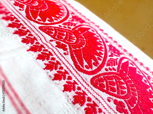 Gamosa or gamusa is a traditional textile pattern from Assam. It is a white piece of cloth with red stripes and red motifs, which is used in Bihu and resembles Ukrainian and Russian patterns. photo