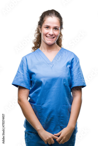 Young brunette doctor girl wearing nurse or surgeon uniform over isolated background with a happy and cool smile on face. Lucky person. © Krakenimages.com