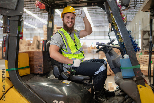 Warehouse worker wears safety helmet driving forklift truck in pallet factory. Skilled male logistic engineer working in shipping storage manufacturing lifting, moving and unloading cargo for delivery