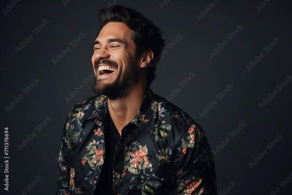 Portrait of a handsome young man laughing against a dark background. Portrait of a handsome young man laughing against a dark background.
