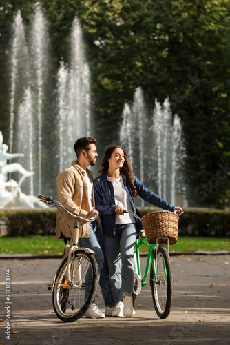 Beautiful couple with bicycles spending time together in park