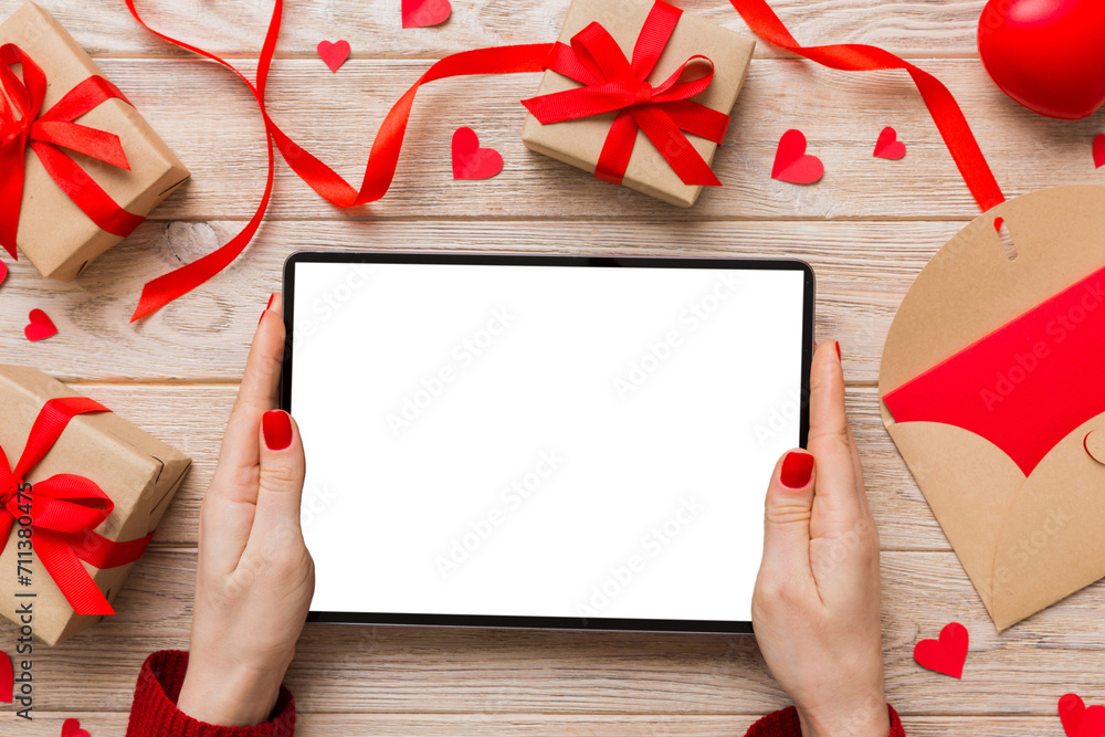 Female hands using a laptop for Valentine day background, gift box and envelope, hearts Female hands using a laptop for Valentine day background, gift box and envelope, hearts