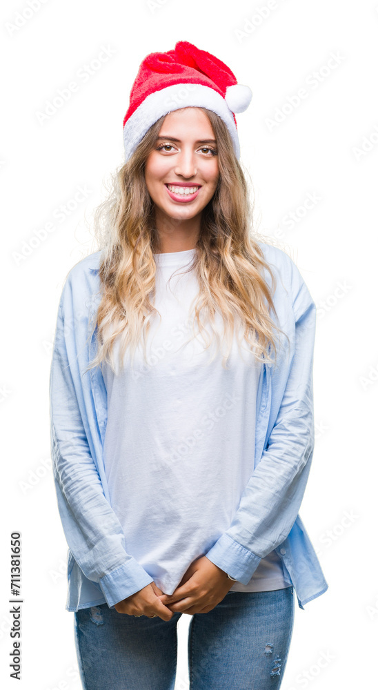 Beautiful young blonde woman wearing christmas hat over isolated background with a happy and cool smile on face. Lucky person. Beautiful young blonde woman wearing christmas hat over isolated background with a happy and cool smile on face. Lucky person.