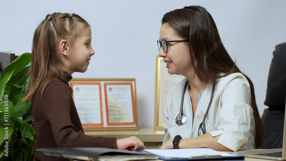 Friendly female pediatrician with stethoscope talking to little patient girl Friendly female pediatrician with stethoscope talking to little patient girl
