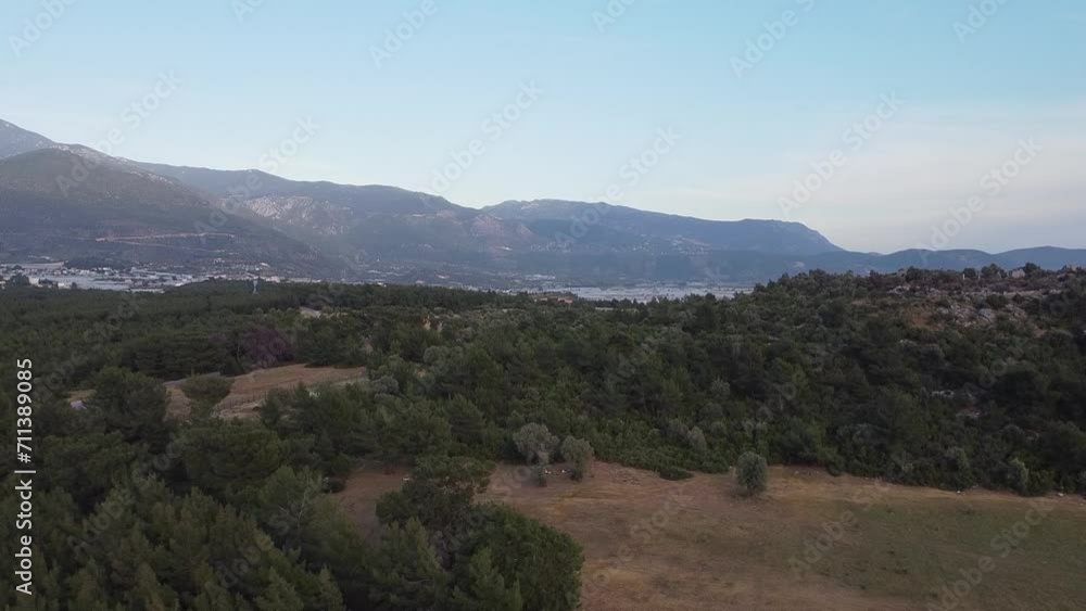 Retreating drone shot of above the woodlands of Sillyon, revealing the town below and showing the mountains from afar, situated in Antalya province in Turkey. Retreating drone shot of above the woodlands of Sillyon, revealing the town below and showing the mountains from afar, situated in Antalya province in Turkey.