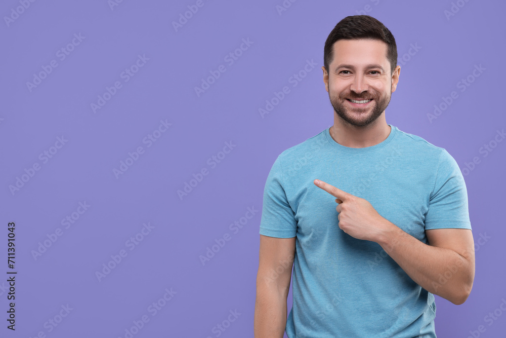 Special promotion. Smiling man pointing at something on purple background. Space for text Special promotion. Smiling man pointing at something on purple background. Space for text