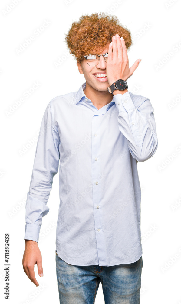 Young handsome business man with afro wearing glasses covering one eye with hand with confident smile on face and surprise emotion. Young handsome business man with afro wearing glasses covering one eye with hand with confident smile on face and surprise emotion.