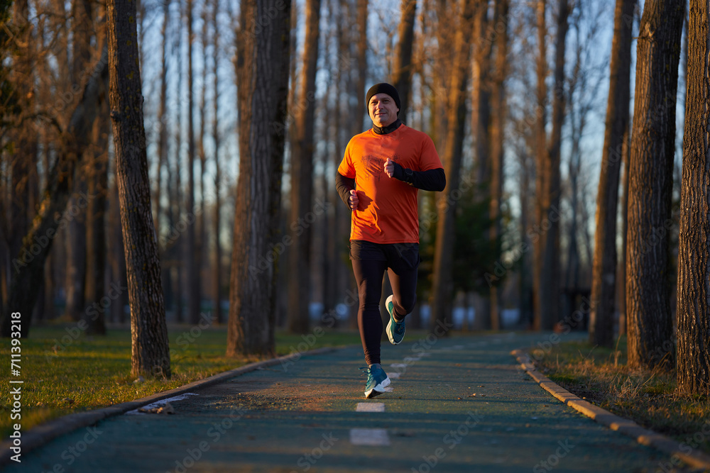 Obraz premium Man running in the park in wintertime