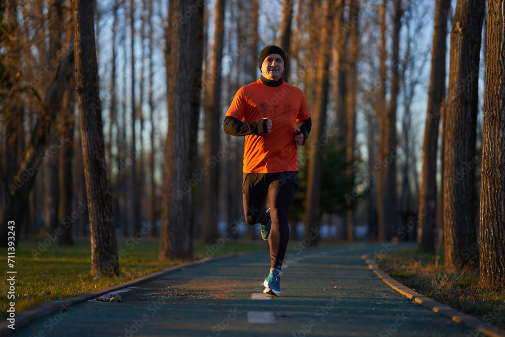 Obraz premium Man running in the park in wintertime