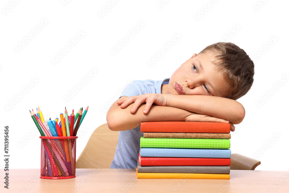 Little boy with stationery and stack of books suffering from dyslexia at wooden table Little boy with stationery and stack of books suffering from dyslexia at wooden table