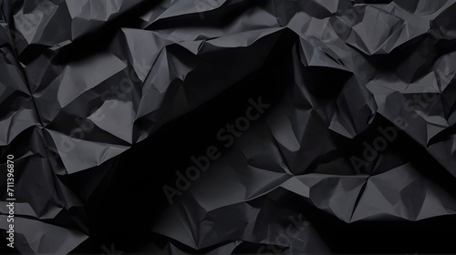 Black crumpled paper texture in low light 