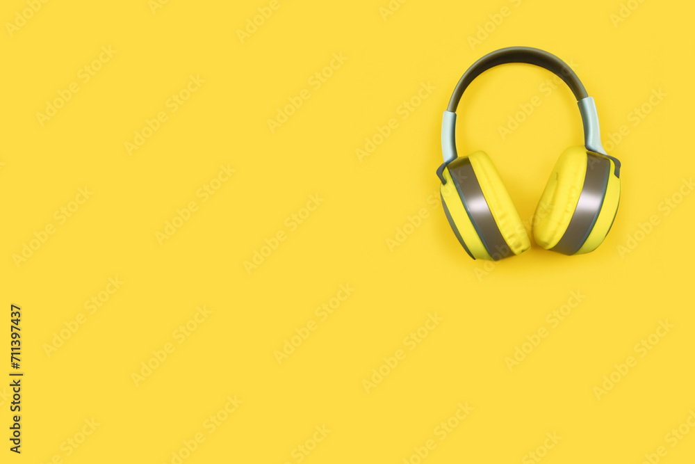 musical composition. gray-yellow headphones lie on a yellow background, top view, creative concept musical composition. gray-yellow headphones lie on a yellow background, top view, creative concept
