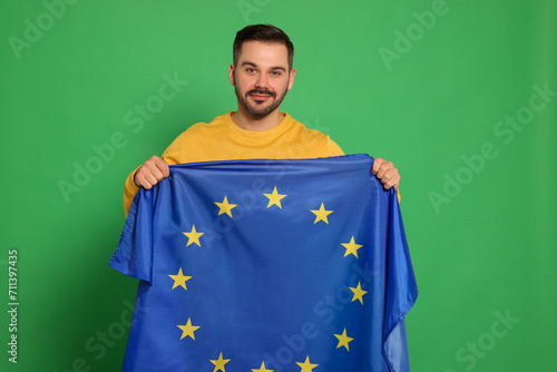 Man with flag of European Union on green background