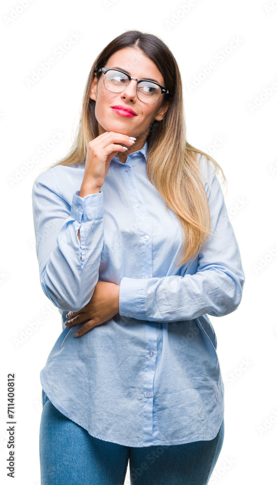 Young beautiful business woman wearing glasses over isolated background with hand on chin thinking about question, pensive expression. Smiling with thoughtful face. Doubt concept. Young beautiful business woman wearing glasses over isolated background with hand on chin thinking about question, pensive expression. Smiling with thoughtful face. Doubt concept.