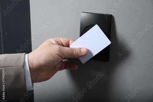 Man opening magnetic door lock with key card, closeup. Home security