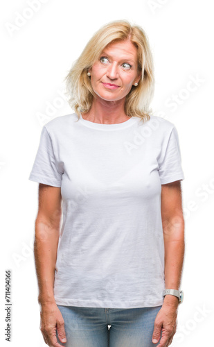 Middle age blonde woman over isolated background smiling looking side and staring away thinking.