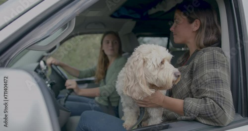 Female Friends with Dog Driving Campervan on Road trip photo