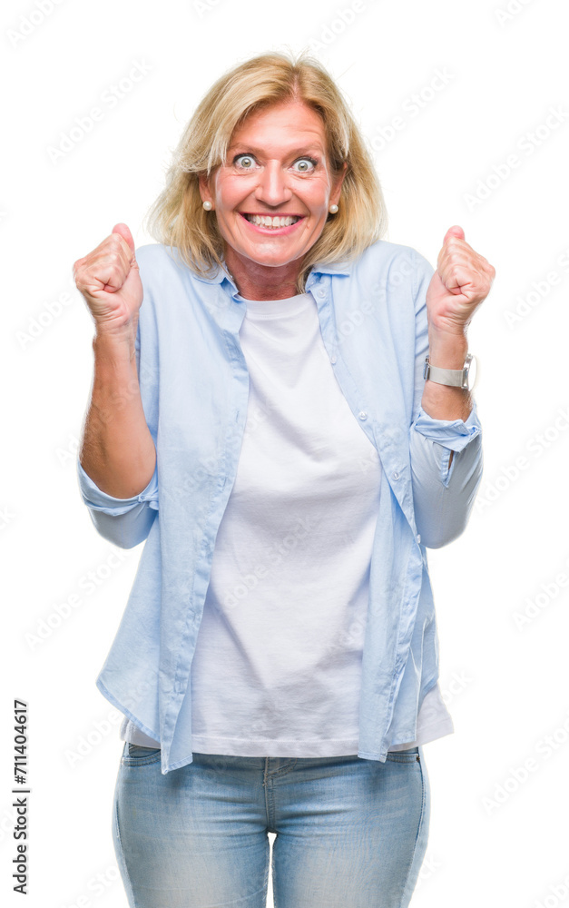 Middle age blonde woman over isolated background celebrating surprised and amazed for success with arms raised and open eyes. Winner concept. Middle age blonde woman over isolated background celebrating surprised and amazed for success with arms raised and open eyes. Winner concept.