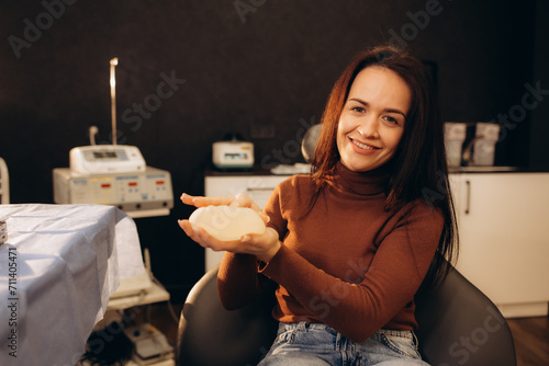 Fotografia Happy woman holding breast implant