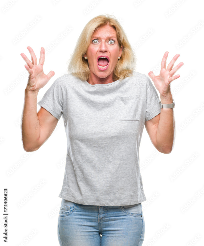 Middle age blonde woman over isolated background crazy and mad shouting and yelling with aggressive expression and arms raised. Frustration concept. Middle age blonde woman over isolated background crazy and mad shouting and yelling with aggressive expression and arms raised. Frustration concept.