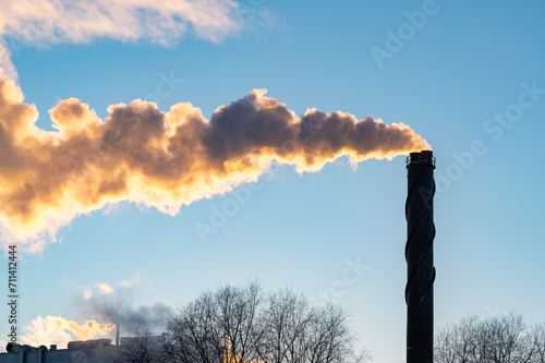 Big chimney with lots of smoke and clear blue sky
