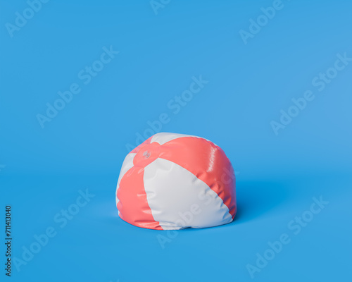 partially inflated red and white beach ball isolated against a vibrant blue background, concept of leisure and summer fun.