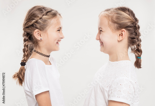 Studioportrait zwei Mädchen lachend im Profil photo