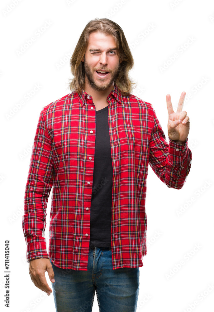 Young handsome man with long hair over isolated background smiling with happy face winking at the camera doing victory sign. Number two. Young handsome man with long hair over isolated background smiling with happy face winking at the camera doing victory sign. Number two.