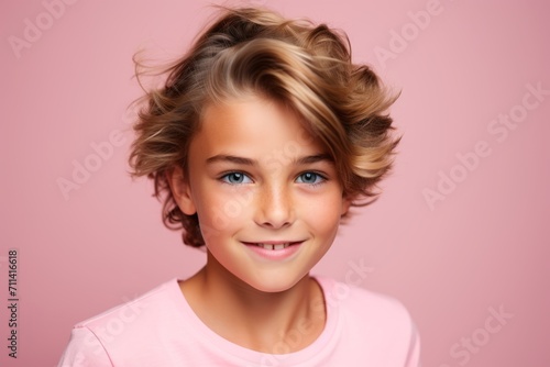 Closeup portrait of a cute little girl with curly hair on pink background