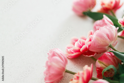 Fototapeta Naklejka Na Ścianę i Meble -  Beautiful tulips on grey stone background, space for text. Stylish floral bouquet. Happy Valentines day and happy mother's day. Tender pink and red flowers wallpaper