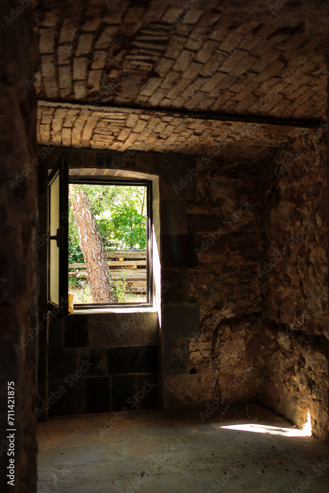 stone basement in an old house during restoration. An open window to the garden.