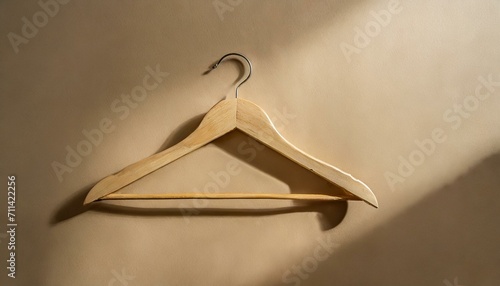 coat hanger.a wooden hanger against a warm beige backdrop. The image should evoke a sense of simplicity and home organization, making it suitable for interior design or lifestyle content. photo