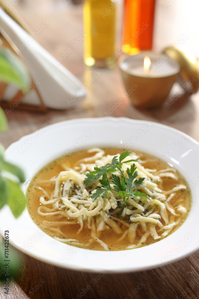 Broth with homemade noodles, sprinkled with parsley, in a white bowl. Lunch at a restaurant, soup, selective focus. Broth with homemade noodles, sprinkled with parsley, in a white bowl. Lunch at a restaurant, soup, selective focus.