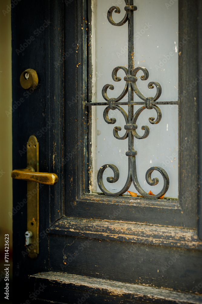 An old antique wooden door decorated with a glass insert with a decorative patterned grille