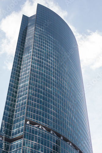 A tall glass business building with large windows. Architecture