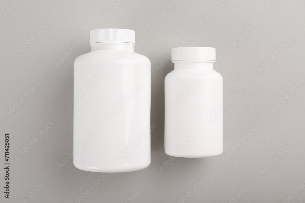 Blank white pill bottles on light grey background, top view Blank white pill bottles on light grey background, top view