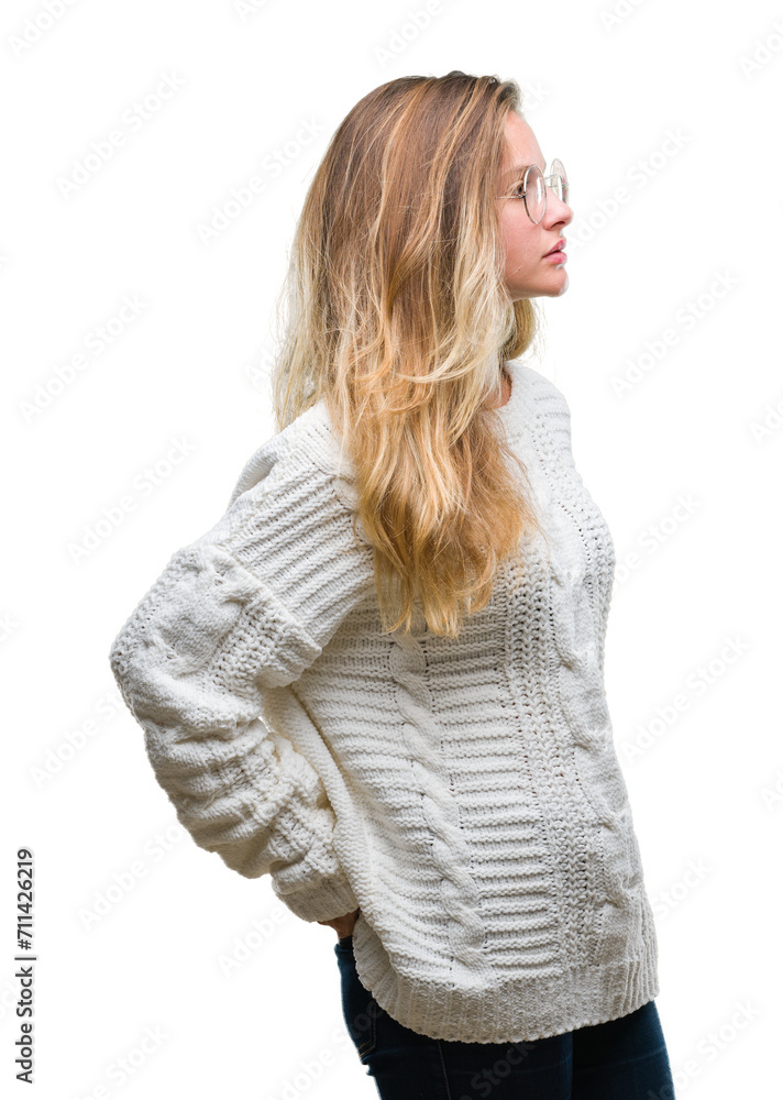 Young beautiful blonde woman wearing winter sweater and sunglasses over isolated background looking to side, relax profile pose with natural face with confident smile. Young beautiful blonde woman wearing winter sweater and sunglasses over isolated background looking to side, relax profile pose with natural face with confident smile.
