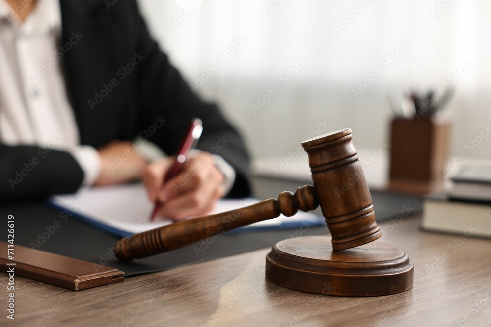 Notary with clipboard writing notes at workplace in office, focus on mallet Notary with clipboard writing notes at workplace in office, focus on mallet