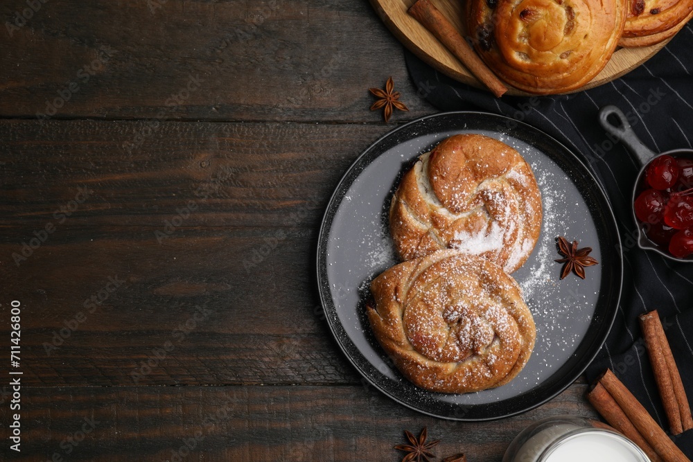 Delicious rolls with sugar powder, berries and spices on wooden table, flat lay with space for text. Sweet buns Delicious rolls with sugar powder, berries and spices on wooden table, flat lay with space for text. Sweet buns