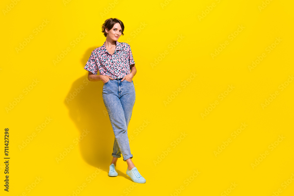 Fototapeta premium Full length photo of stunning lovely person put arms pockets posing empty space information ad isolated on yellow color background