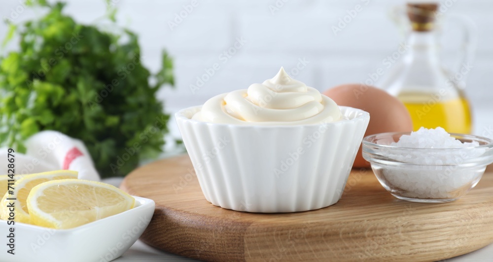 Fresh mayonnaise sauce in bowl and ingredients on table Fresh mayonnaise sauce in bowl and ingredients on table