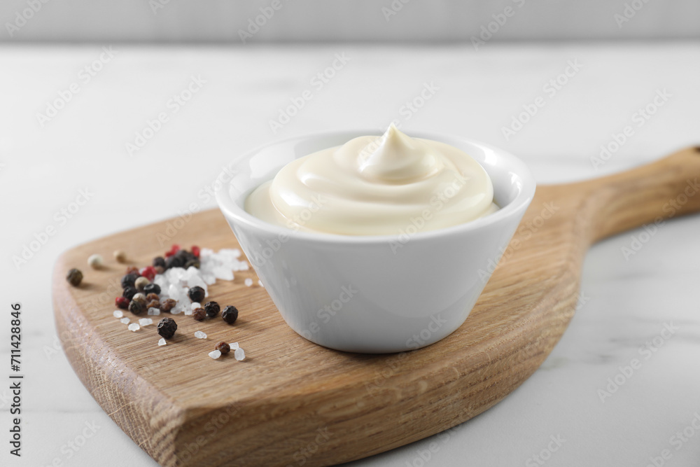 Tasty mayonnaise sauce in bowl and spices on white table, closeup Tasty mayonnaise sauce in bowl and spices on white table, closeup