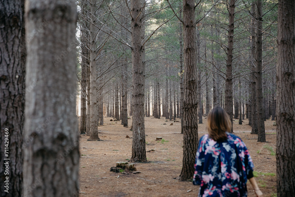 Woman wearing a bright blue kimono walking into a forrest Woman wearing a bright blue kimono walking into a forrest