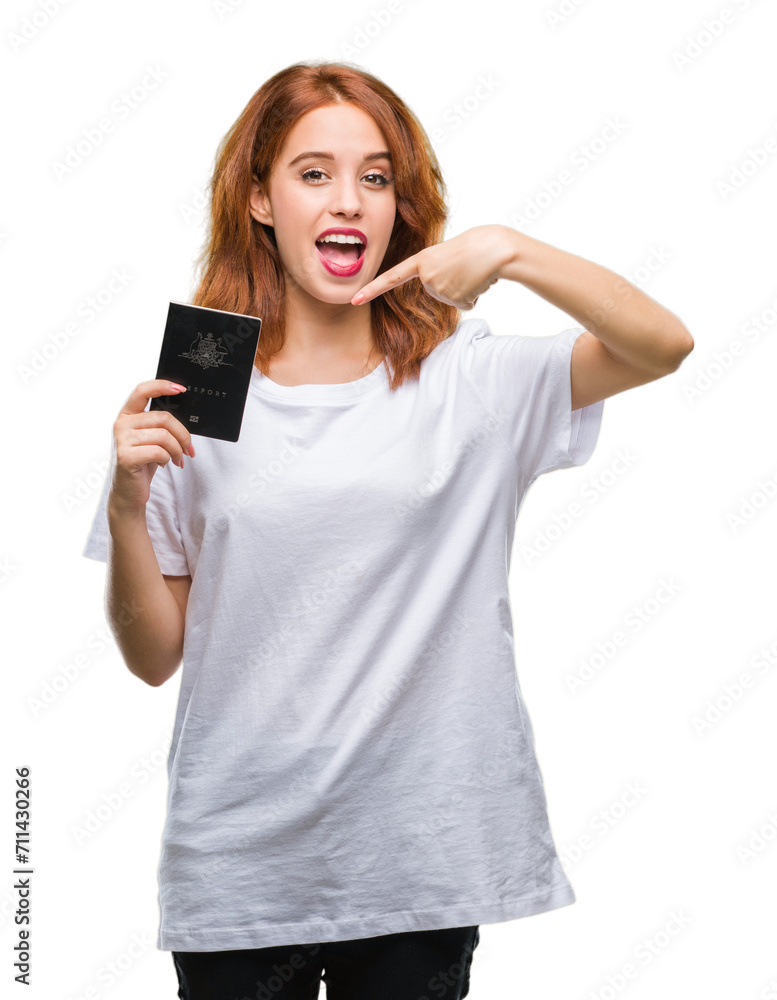 Young beautiful woman holding passport of australia over isolated background very happy pointing with hand and finger