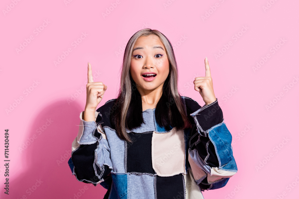 Portrait of impressed woman with dyed hairdo wear oversize sweatshirt indicating at discount empty space isolated on pink color background Portrait of impressed woman with dyed hairdo wear oversize sweatshirt indicating at discount empty space isolated on pink color background