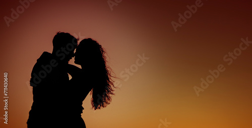 Couple of unrecognizable lovers hugging each other against the light