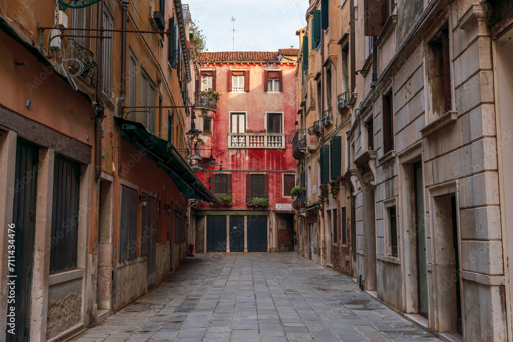 Lonely path way along the Venetian city with high facades and mystic shadows Lonely path way along the Venetian city with high facades and mystic shadows