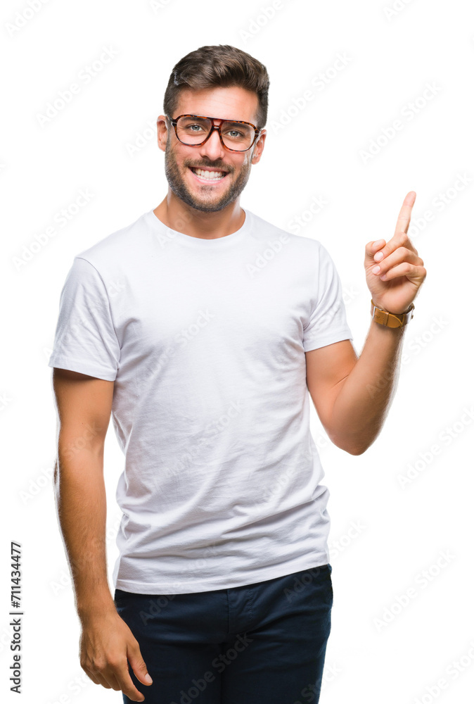 Young handsome man wearing glasses over isolated background with a big smile on face, pointing with hand and finger to the side looking at the camera. Young handsome man wearing glasses over isolated background with a big smile on face, pointing with hand and finger to the side looking at the camera.